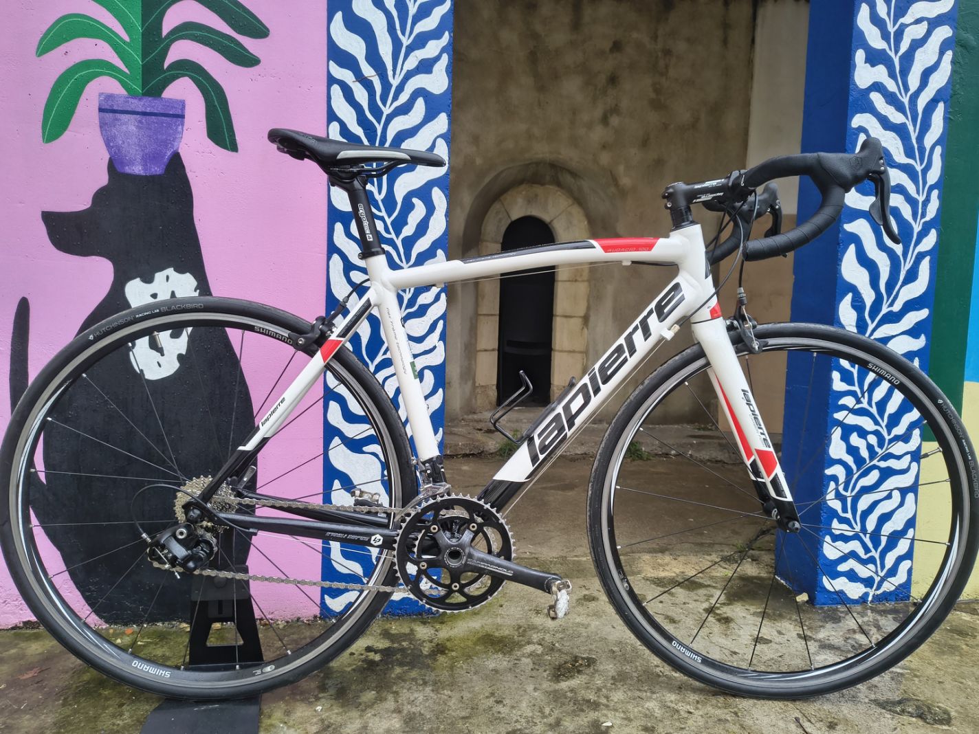 Vélo fitness BMC rouge avec cintre plat, mono-plateau et freins à disque